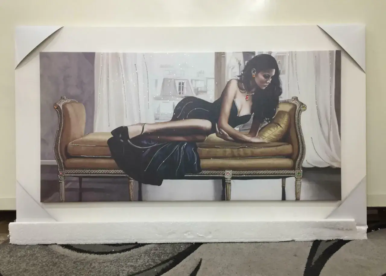 Quadro con donna elegante sdraiata su un divano dorato, un'opera d'arte che cattura l'essenza del lusso e della seduzione, perfetta per decorare sopra un divano.