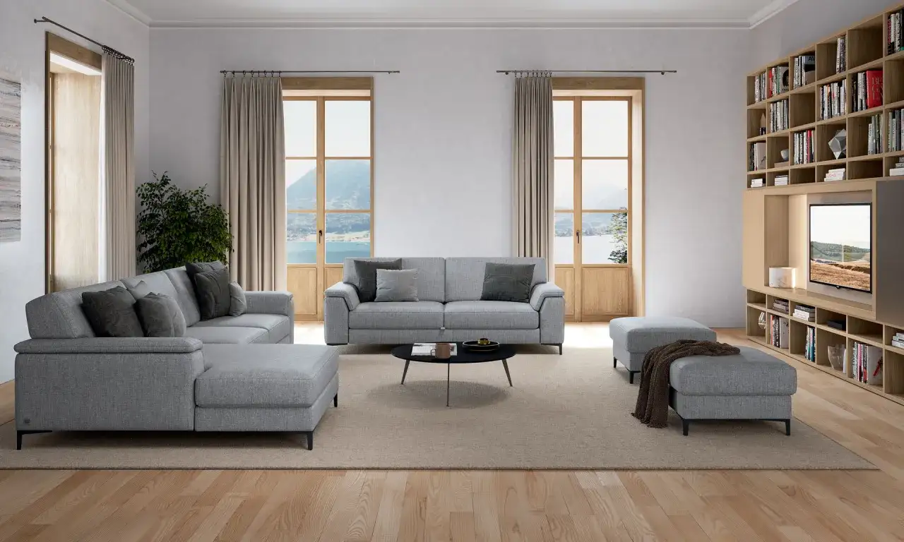 Un salotto moderno con divani grigi, tavolino nero e un tappeto beige. Ideale per capire come scegliere tappeto salotto.