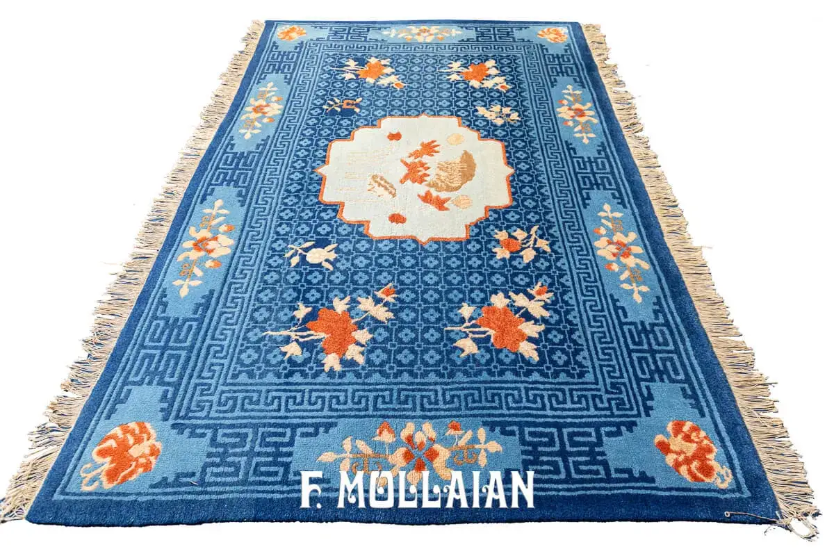 Tappeto cinese blu con motivi floreali arancioni e un disegno centrale in stile medaglione. Bordi decorati con greche.