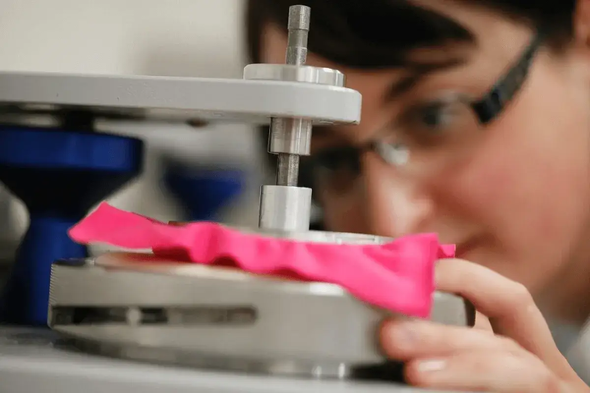 Ricerca sulla resistenza dei tessuti, un campione rosa viene testato.