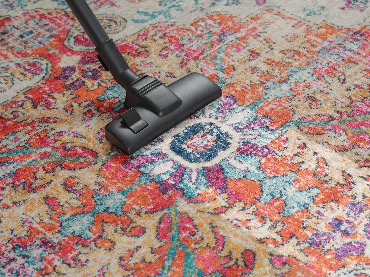 Spolverare un tappeto persiano colorato con bicarbonato per una pulizia profonda.