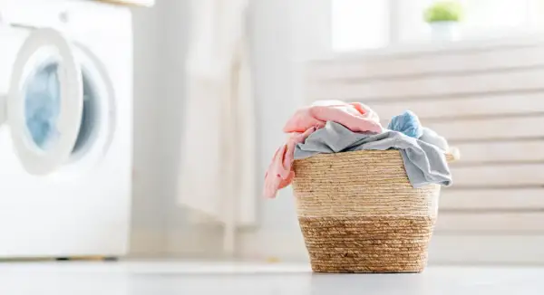 Cesto di biancheria colorata pronto per il lavaggio. Scopri come far profumare il bucato con trucchi semplici e naturali.