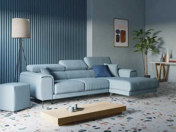 Accogliente soggiorno con divano azzurro, tavolino in legno, lampada da terra e un quadro astratto.