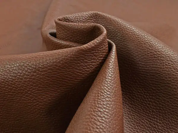 Tessuto di pelle pieno fiore marrone, con una texture granulosa che ne esalta il significato di qualità e naturalezza.