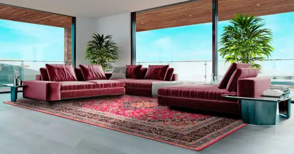 Soggiorno moderno con divano bordeaux e un tappeto persiano dai colori vivaci, che mostra diversi tipi di tappeti persiani.