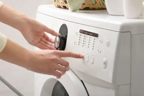 Mani impostano la lavatrice, scegliendo il programma e la durata centrifuga lavatrice.