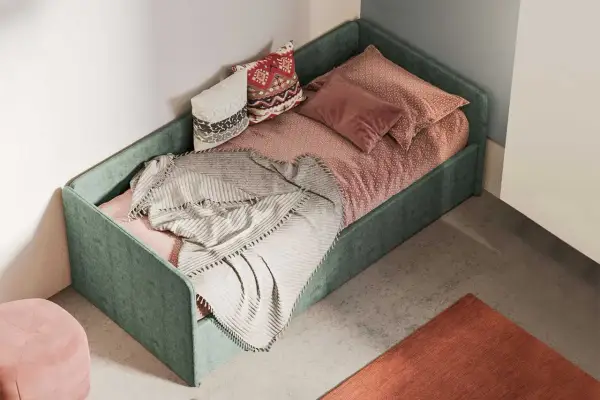 Divano fai da te con letto singolo, verde, con cuscini decorativi e coperta morbida.